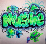 Original hand-airbrushed Mushie graffiti name in lime green and turquoise, surrounded by colorful mushrooms, black curls, purple shading and white highlights on fabric.